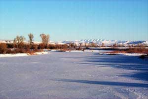 The Sawtooth Range is visible in the distance beyond a frozen Green River.